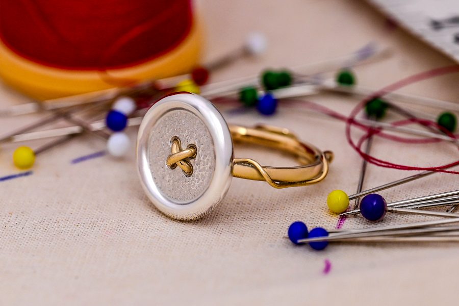 Button and thread ring displayed with pins and cotton reel
